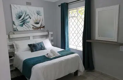 a bed in a bedroom with a window and a bedvisor at Sabie Star in Sabie
