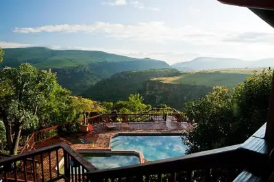 a view of a swimming pool with mountains in the background at Acra-Retreat Mountain View Lodge in Waterval Boven