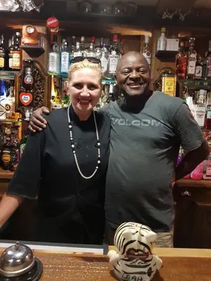 a man and a woman standing in a bar at Acra-Retreat Mountain View Lodge in Waterval Boven