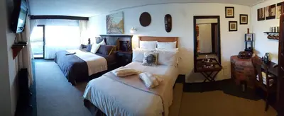 a hotel room with two beds and a mirror at Acra-Retreat Mountain View Lodge in Waterval Boven