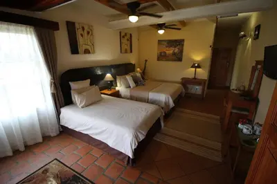 a hotel room with two beds and a window at Acra-Retreat Mountain View Lodge in Waterval Boven