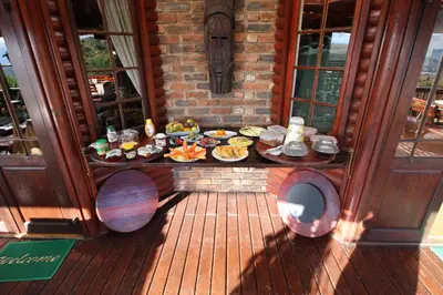 a table with plates of food on a deck at Acra-Retreat Mountain View Lodge in Waterval Boven