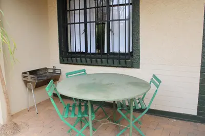 a green table and chairs sitting next to a wall at Honey Lodge in Klipdrift