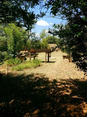 a picnic table and bench in a park at Honey Lodge in Klipdrift