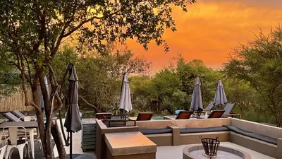 an outdoor patio with tables and umbrellas and chairs at Lindiwe Safari Lodge in Hoedspruit