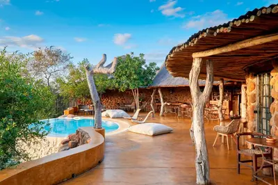 an outdoor patio with a swimming pool and a house at Geiger's Camp in Timbavati Game Reserve by NEWMARK in Timbavati Game Reserve