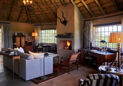 a living room with a couch and a fireplace at Geiger's Camp in Timbavati Game Reserve by NEWMARK in Timbavati Game Reserve