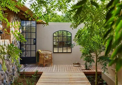 a patio with a chair and a door and trees at Geiger's Camp in Timbavati Game Reserve by NEWMARK in Timbavati Game Reserve