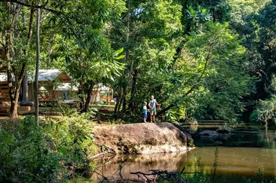 two people standing on a rock near a river at AfriCamps at Mackers in Hazyview