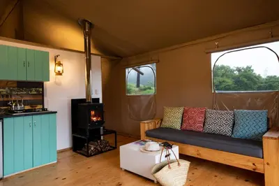 a living room with a couch and a stove at AfriCamps at Mackers in Hazyview