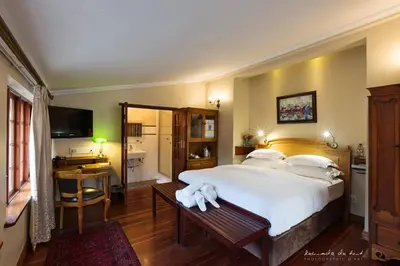 a bedroom with a large white bed and a desk at Kleinkaap Boutique Hotel in Centurion
