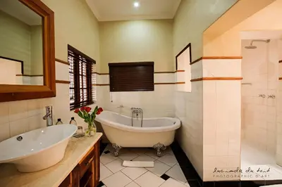 a bathroom with a tub and a sink and a mirror at Kleinkaap Boutique Hotel in Centurion