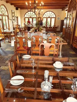 a dining room with a wooden table and chairs at Kleinkaap Boutique Hotel in Centurion