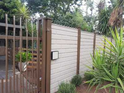 a fence with a wooden gate in a garden at Ubuntu Guesthouse in Pretoria