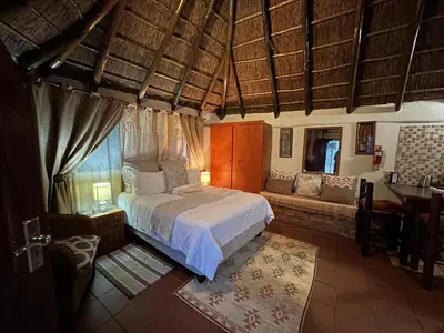 a bedroom with a bed and a couch in a room at Ubuntu Guesthouse in Pretoria