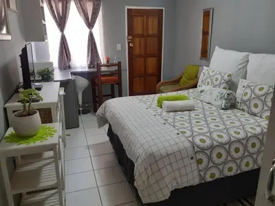 a bedroom with a bed and a living room at Ubuntu Guesthouse in Pretoria