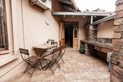 a patio with chairs and a table on a house at Selati 103 Guest Cottages in Malelane