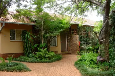 a house with a brick driveway in front of it at Selati 103 Guest Cottages in Malelane