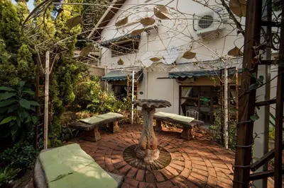 a patio with two benches and a building at Tamboti Lodge Guest House in Tzaneen