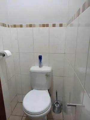 a bathroom with a toilet with a blue bottle on it at Tokelo Guesthouse Emalahleni in Witbank
