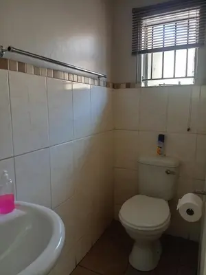 a bathroom with a toilet and a sink and a tub at Tokelo Guesthouse Emalahleni in Witbank