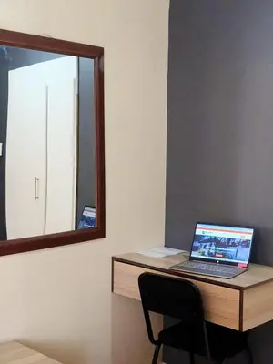 a laptop computer sitting on a desk with a mirror at Tokelo Guesthouse Emalahleni in Witbank