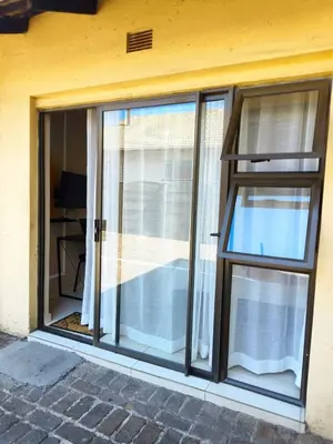 a sliding glass door with windows on a building at Tokelo Guesthouse Emalahleni in Witbank
