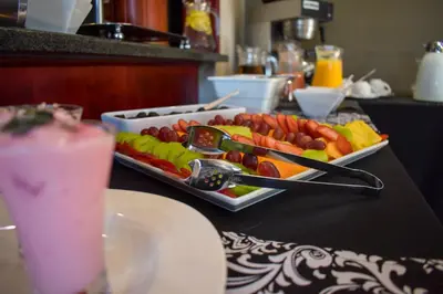 a tray of fruits and vegetables on a table with a drink at Waterfalls Boutique Hotel in Pretoria
