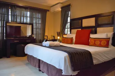 a bedroom with a large bed and a piano at Waterfalls Boutique Hotel in Pretoria