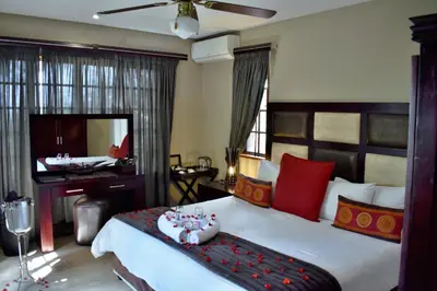a bedroom with a large bed and a mirror at Waterfalls Boutique Hotel in Pretoria