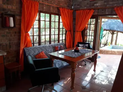 a living room with a wooden table and chairs at Little Bush Baby in Marloth Park