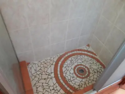 a bathroom with a shower with a mosaic floor at Little Bush Baby in Marloth Park