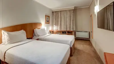 a hotel room with two beds and a television at StayEasy Pretoria in Pretoria