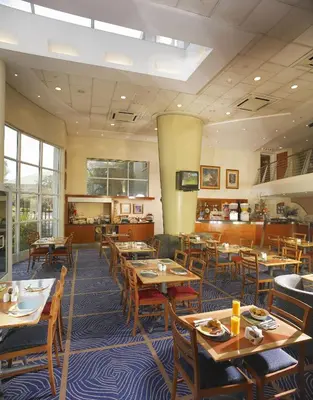 a dining room with wooden tables and chairs at StayEasy Pretoria in Pretoria