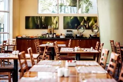 a restaurant with tables and chairs in a room at StayEasy Pretoria in Pretoria