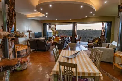 a living room with a table and chairs at Leopards Rock Bush Boutique in Bela-Bela