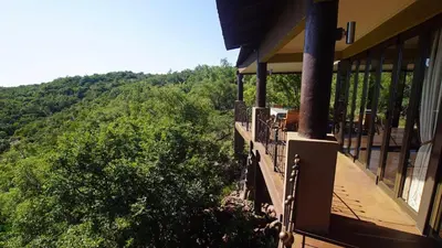 a balcony of a house with a view of trees at Leopards Rock Bush Boutique in Bela-Bela