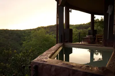 a swimming pool on the side of a house at Leopards Rock Bush Boutique in Bela-Bela