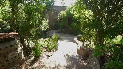 a garden with a walkway in front of a house at Leopards Rock Bush Boutique in Bela-Bela
