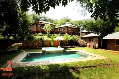 a swimming pool in the yard of a house at Zongororo Mountain Lodge in Waterval-Onder