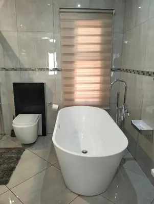 a white bath tub in a bathroom with a toilet at Sunrise Boutique Hotel in Witbank