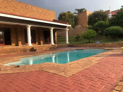 a swimming pool in front of a brick building at Sunrise Boutique Hotel in Witbank