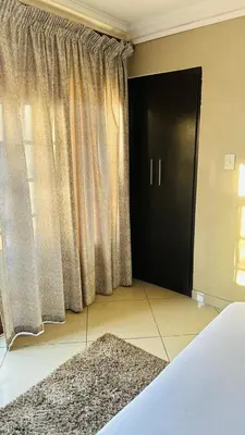 a bedroom with a bed and a black door and a rug at Sunrise Boutique Hotel in Witbank
