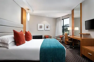 a hotel room with a large bed and a desk at Premier Hotel O.R. Tambo in Kempton Park