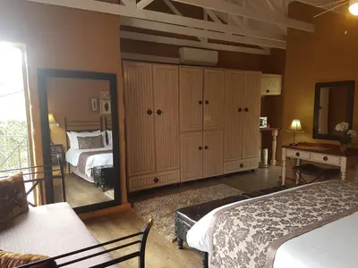 a bedroom with two beds and a mirror at Chateau Vue Guesthouse in Pretoria