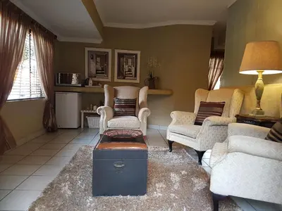 a living room with a couch and chairs and a table at Chateau Vue Guesthouse in Pretoria