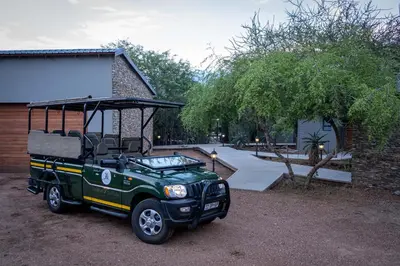 a green jeep parked in front of a house at Tamboti River Lodge in Hectorspruit