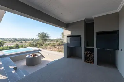 a house with a view of a pool at Tamboti River Lodge in Hectorspruit