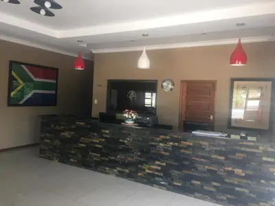 a lobby with a reception desk and red lights at Vahlavi Lodge in Giyani
