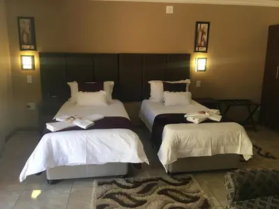 a hotel room with two beds with towels on them at Vahlavi Lodge in Giyani
